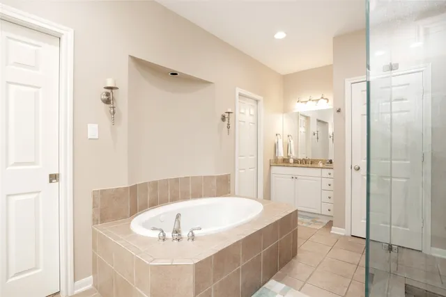 a bathroom with a tub a sink and a shower