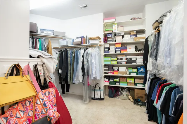 a view of walk in closet with clothes and shoes