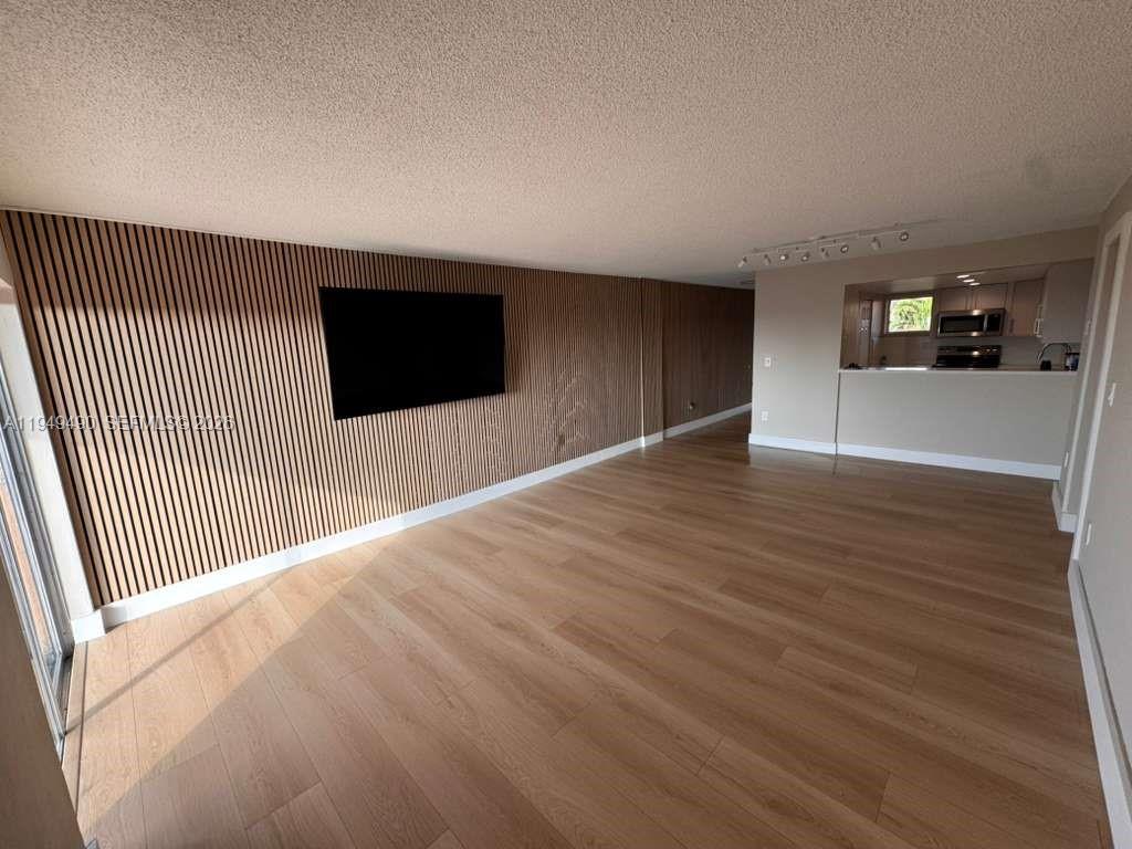 a view of a livingroom with wooden floor and a flat screen tv