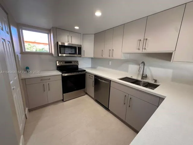 a kitchen with sink a microwave and cabinets