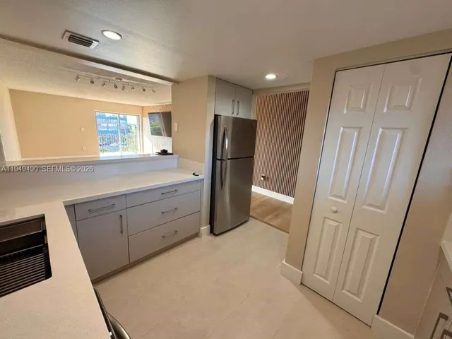 a view of a refrigerator in kitchen and a sink