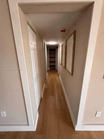 a view of a hallway with wooden floor and stairs