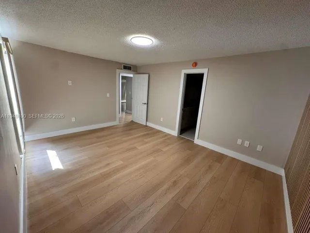 an empty room with closet and mirror