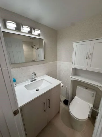 a bathroom with a toilet sink and mirror