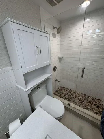 a bathroom with a toilet a sink and shower