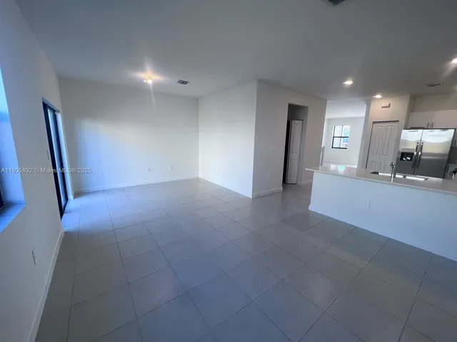a view of a hallway to a room with a sink