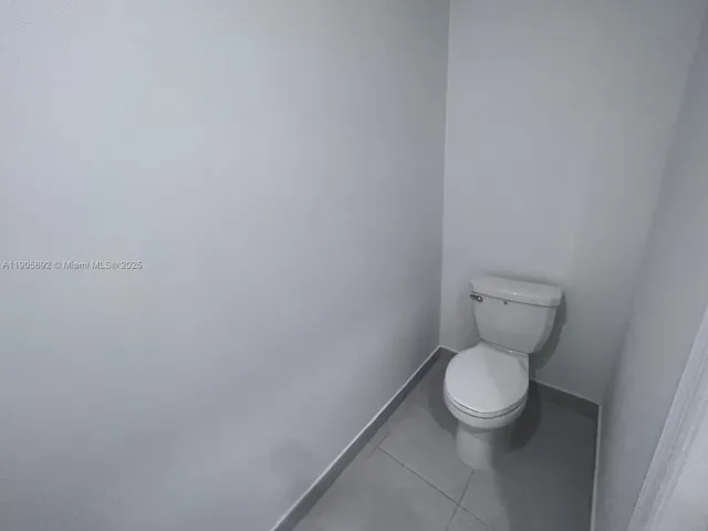 a white toilet sitting next to a white cabinet