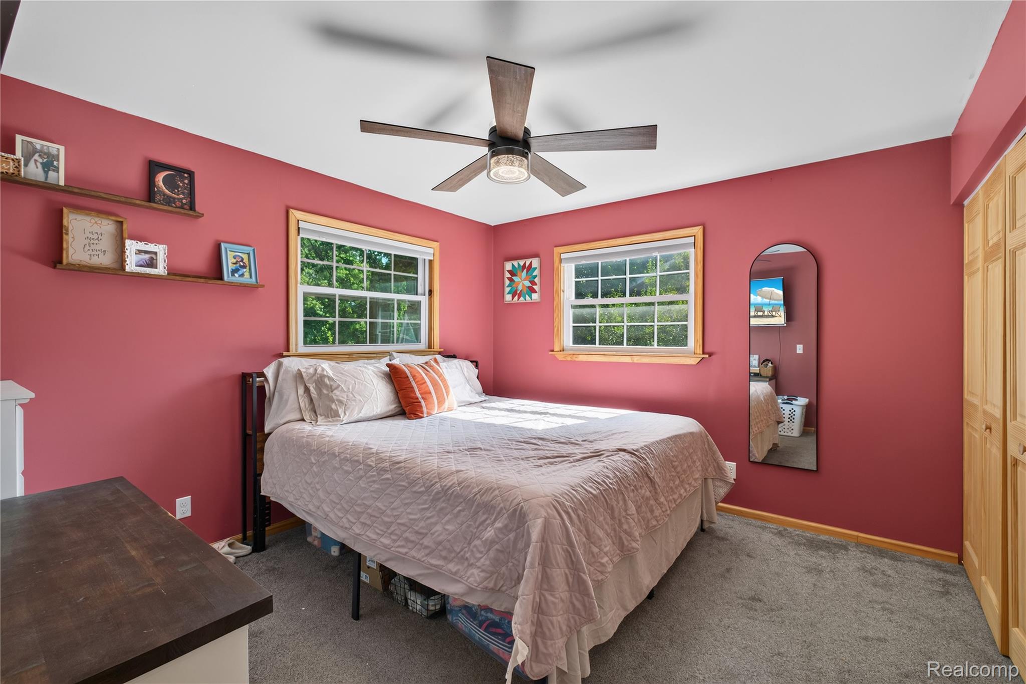 5282 West Mount Morris Road Mount Morris, MI 48458 - Photo 13 of 23 Bright secondary bedroom features vibrant coral walls, dual windows with natural light, ceiling fan with integrated lighting, wood-finish flooring, and ample wall space for furnishings and décor