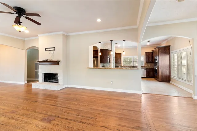 a view of a kitchen and an empty room with wooden floor kitchen view