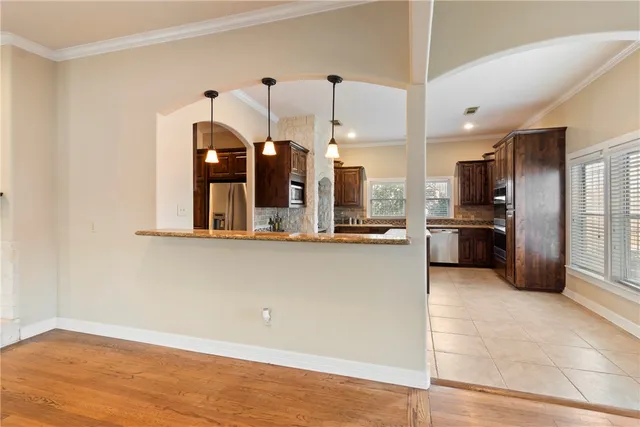 a large kitchen with a large counter top stainless steel appliances and cabinets