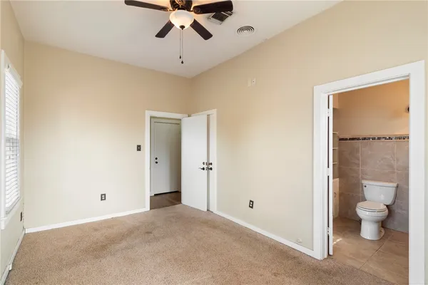 a view of a livingroom with a chandelier fan and a bathroom
