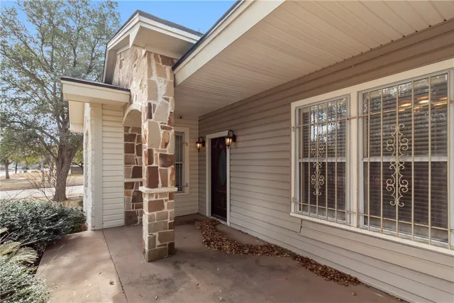 a view of a house with a large window and wooden fence