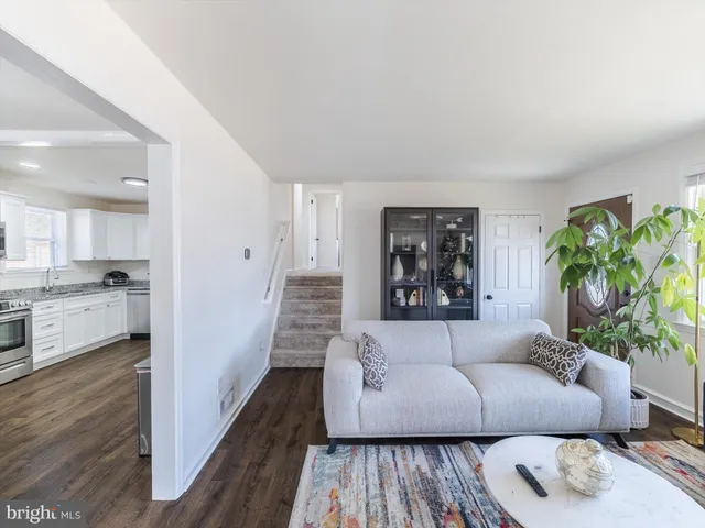 a living room with furniture and a large window with wooden floor