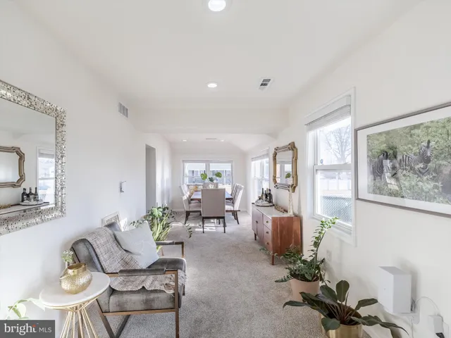 a living room with furniture potted plant and a large window