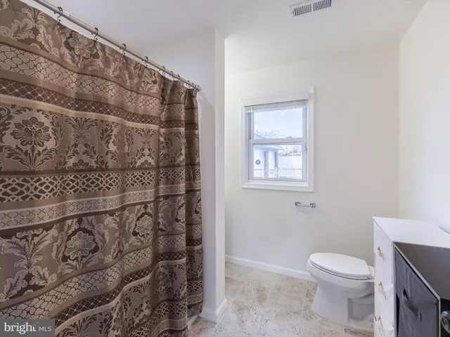 a bathroom with a toilet and a shower curtain