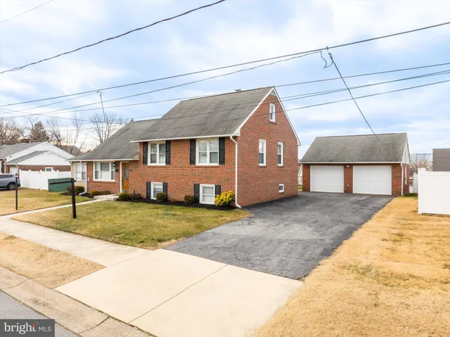 a view of a house with a patio and a yard
