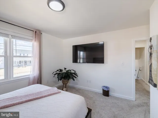 a bedroom with a bed and a potted plant