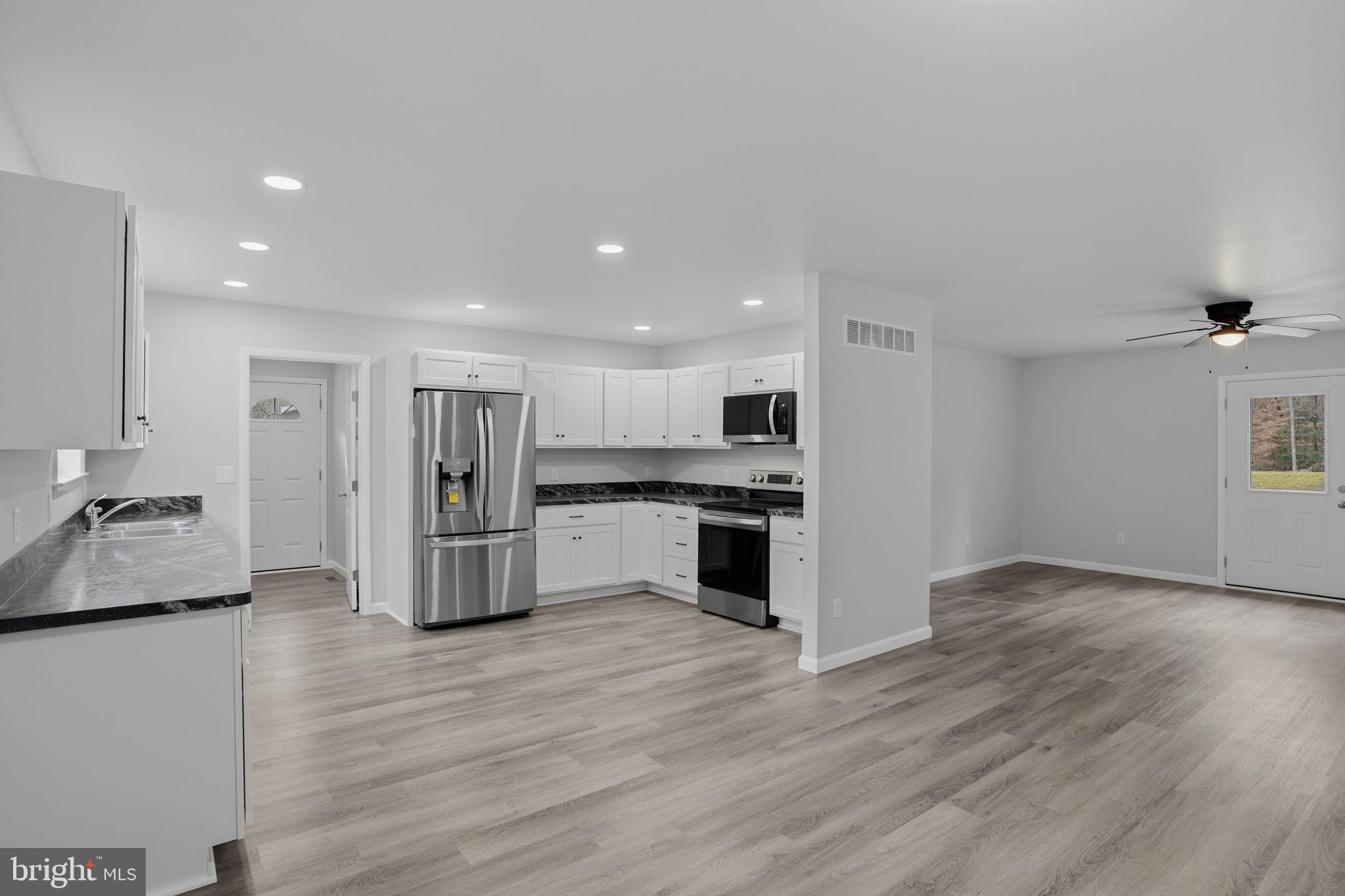 897 Horsepen Road Felton, DE 19943 - Photo 14 of 38 a large kitchen with a center island wooden floor and stainless steel appliances