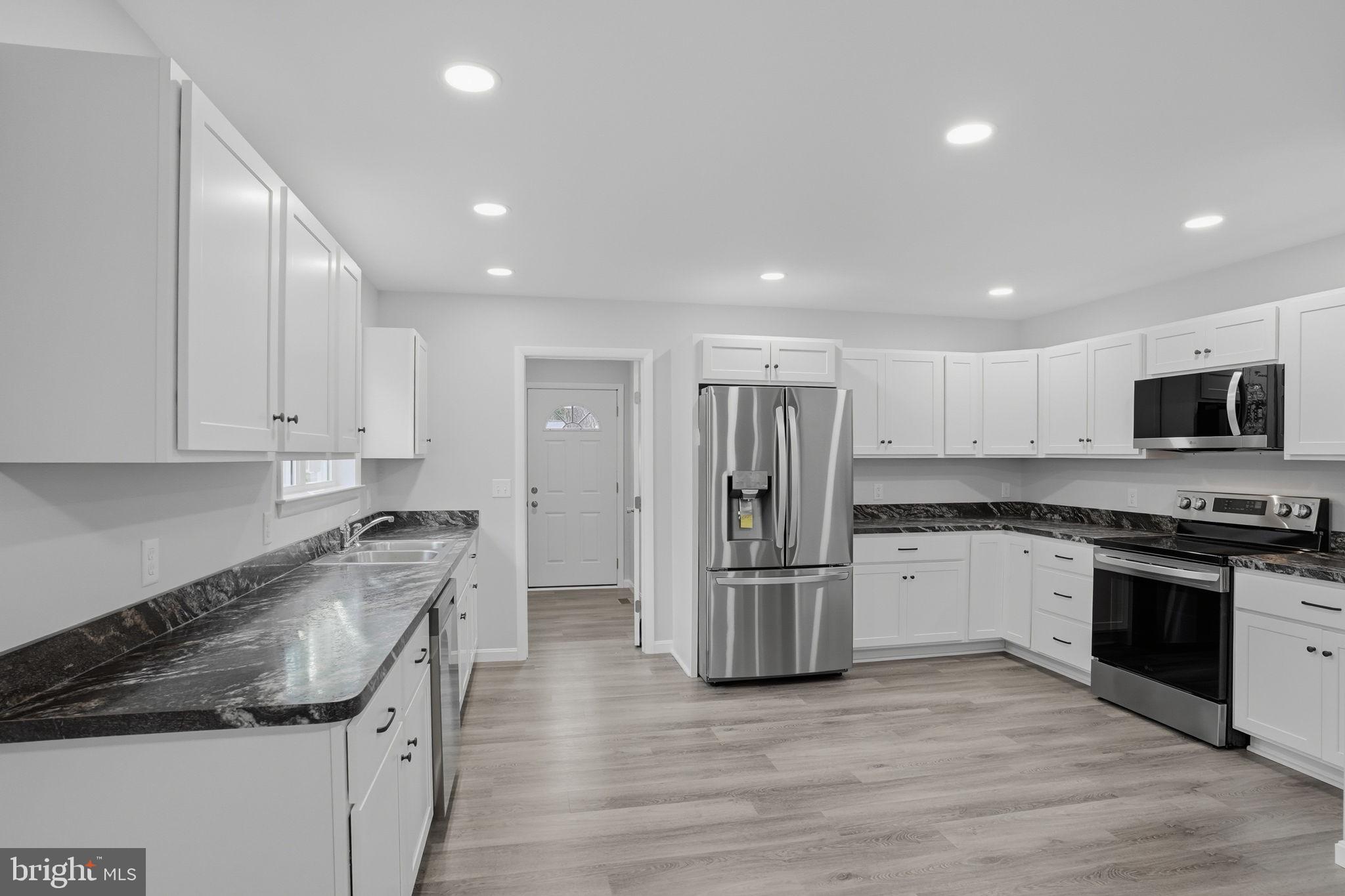897 Horsepen Road Felton, DE 19943 - Photo 15 of 38 a kitchen with stainless steel appliances granite countertop a refrigerator and a stove top oven