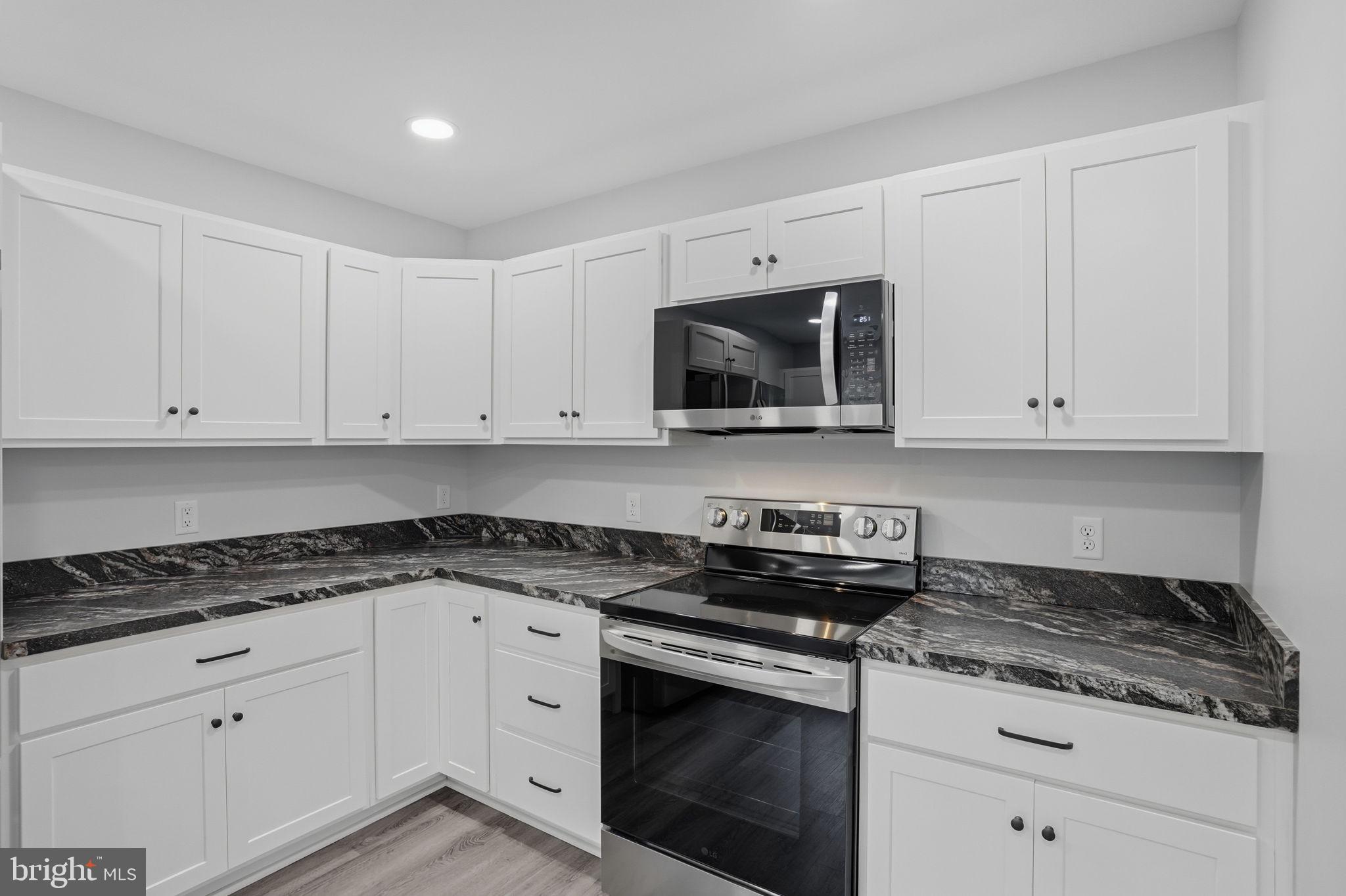 897 Horsepen Road Felton, DE 19943 - Photo 17 of 38 a kitchen with granite countertop white cabinets white stainless steel appliances and granite counter tops
