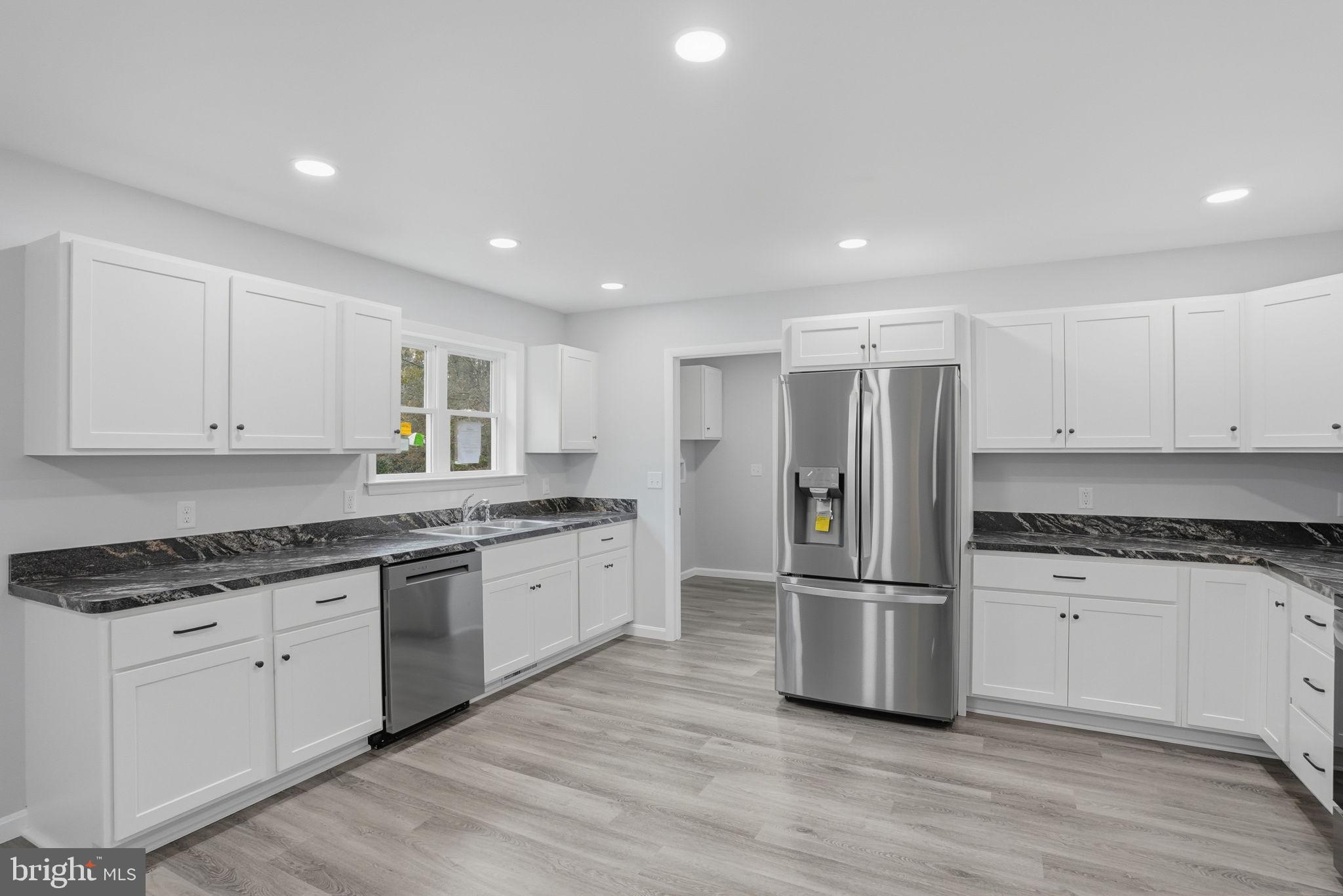 897 Horsepen Road Felton, DE 19943 - Photo 18 of 38 a kitchen with granite countertop a refrigerator and white cabinets