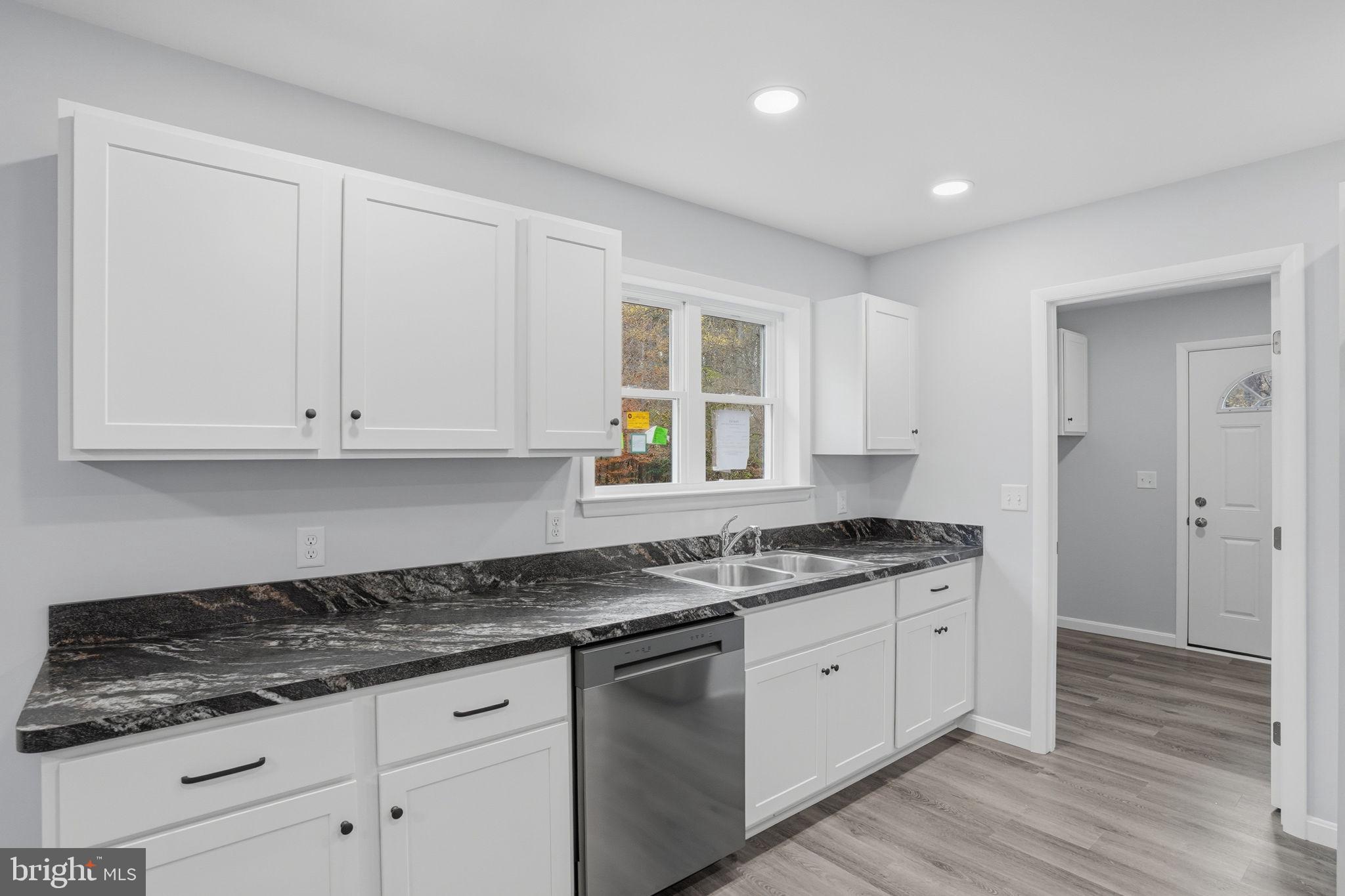 897 Horsepen Road Felton, DE 19943 - Photo 19 of 38 a kitchen with stainless steel appliances granite countertop a stove a sink and white cabinets