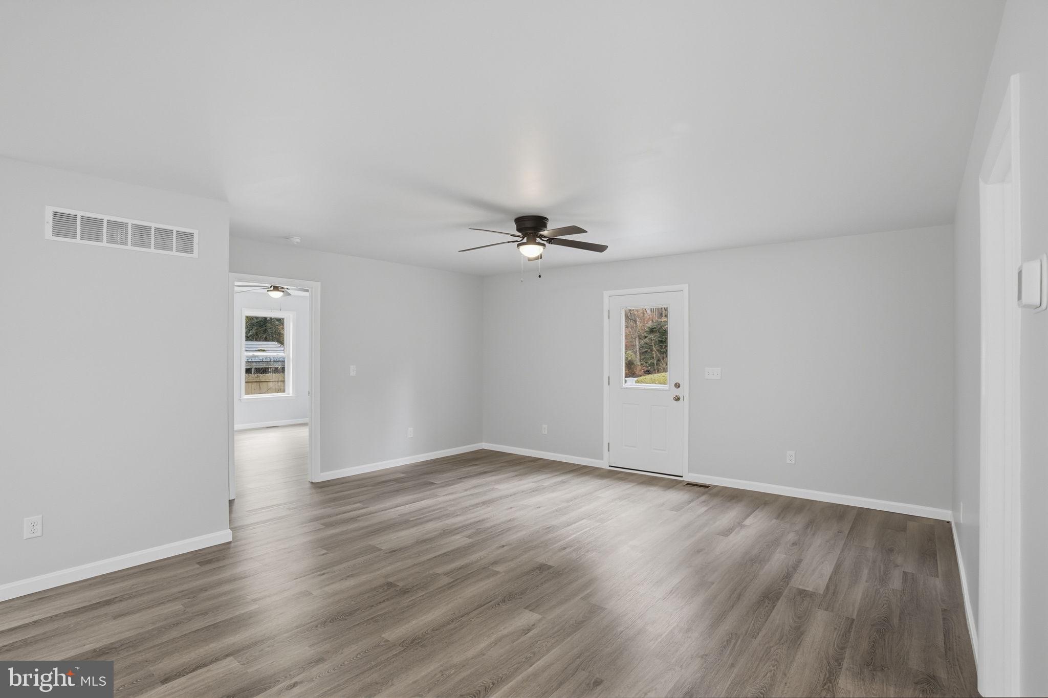 897 Horsepen Road Felton, DE 19943 - Photo 25 of 38 an empty room with wooden floor ceiling fan and windows