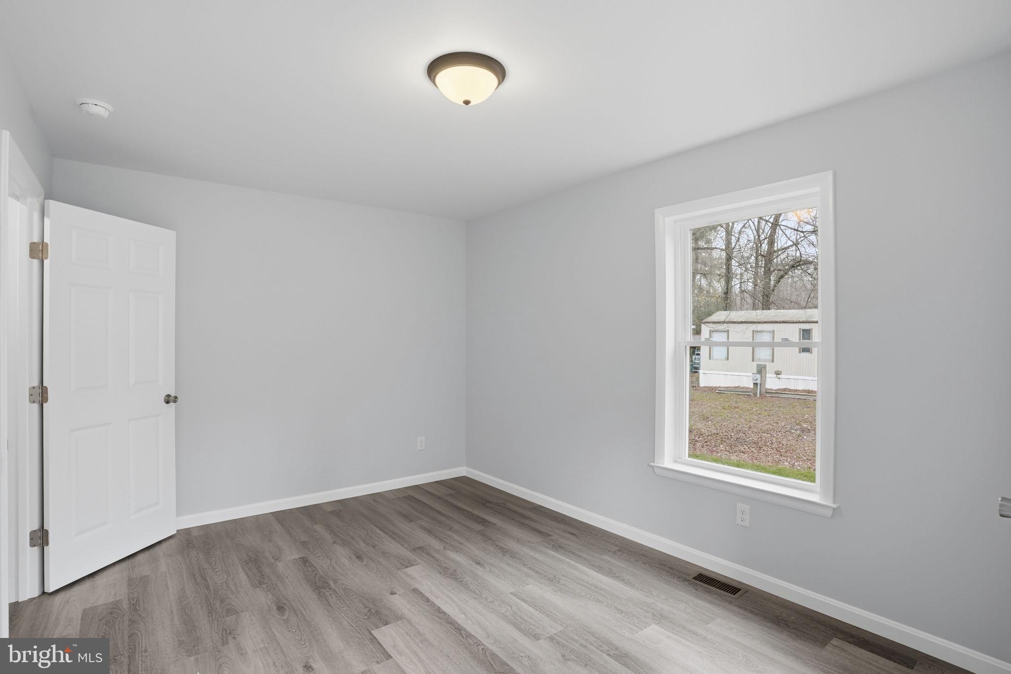 897 Horsepen Road Felton, DE 19943 - Photo 31 of 38 a view of an empty room with wooden floor and a window