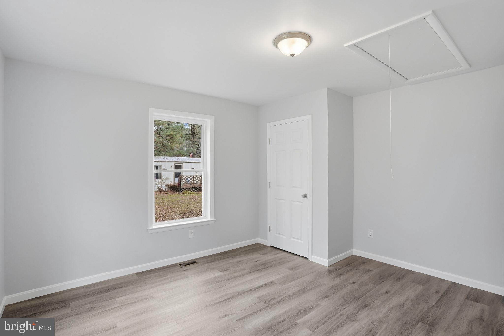 897 Horsepen Road Felton, DE 19943 - Photo 33 of 38 an empty room with wooden floor and windows