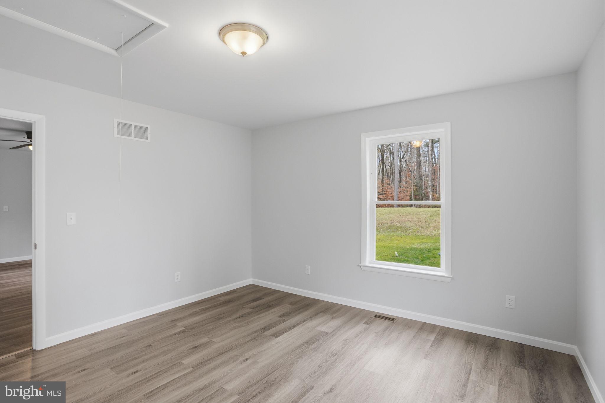897 Horsepen Road Felton, DE 19943 - Photo 34 of 38 an empty room with wooden floor and windows