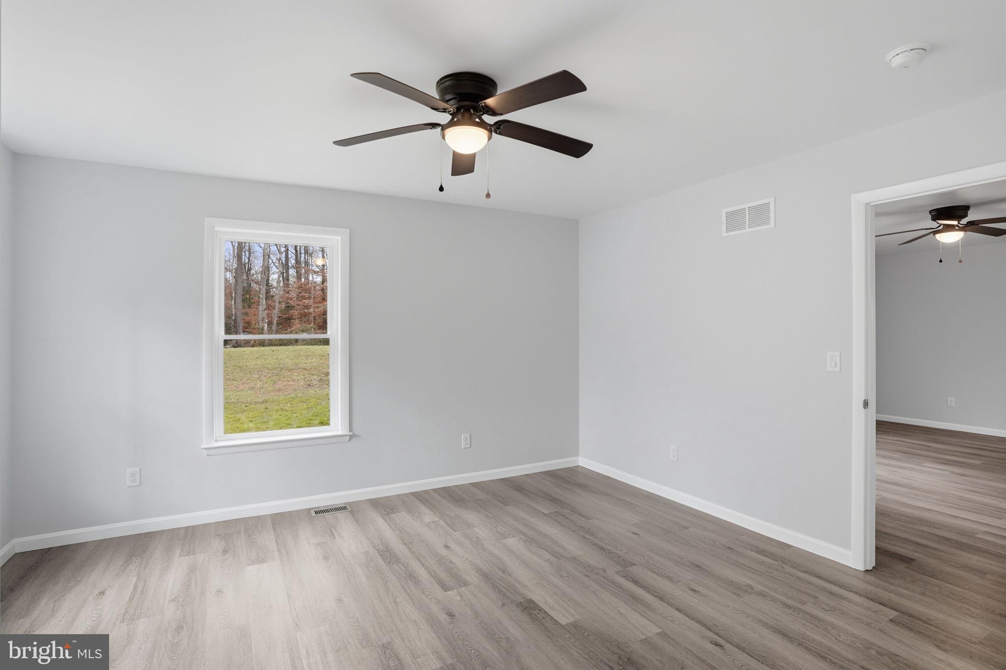 897 Horsepen Road Felton, DE 19943 - Photo 37 of 38 an empty room with wooden floor ceiling fan and window
