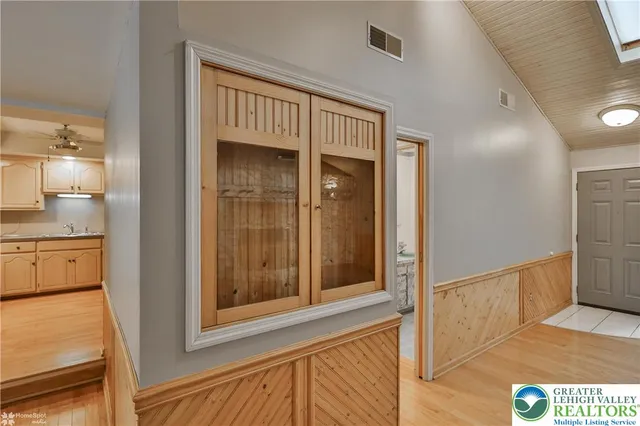 a view of hallway with bathroom and wooden floor
