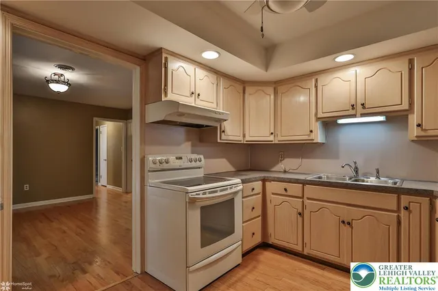 a kitchen with stainless steel appliances granite countertop a sink a stove a refrigerator and cabinets