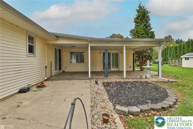 a view of a white house with a big yard and large trees