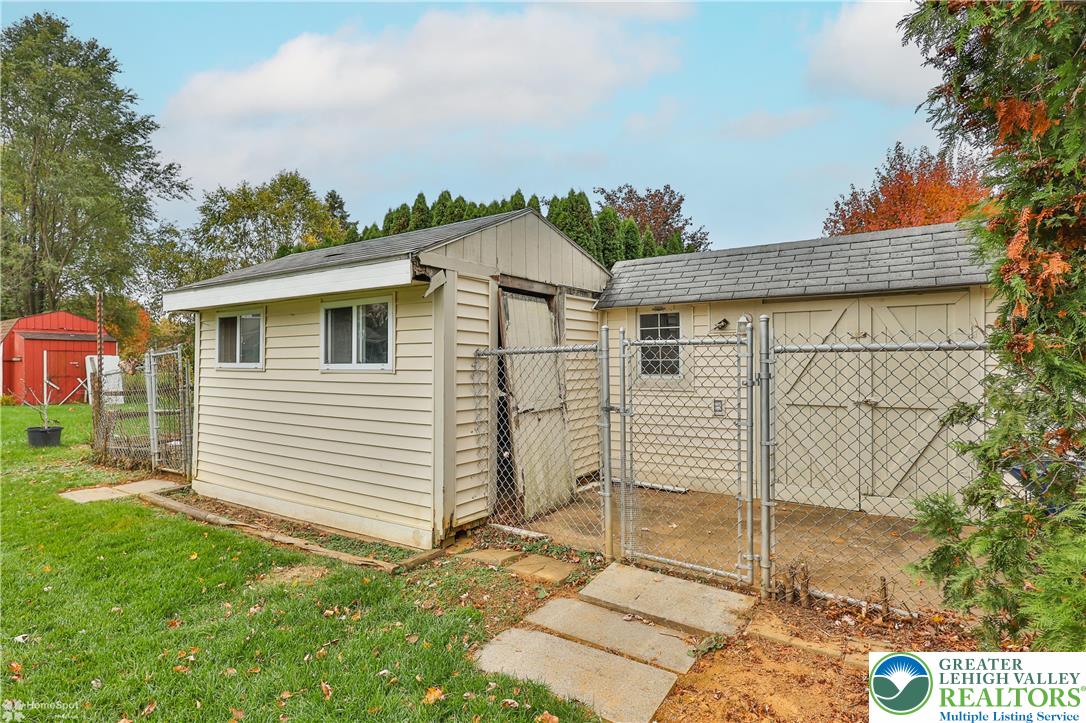 900 Mine Lane Road Easton, PA 18045 - Photo 48 of 51 a view of a white house with a yard and table and chairs under an umbrella