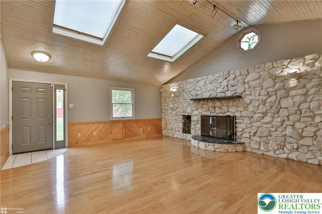 a view of empty room with wooden floor and fireplace