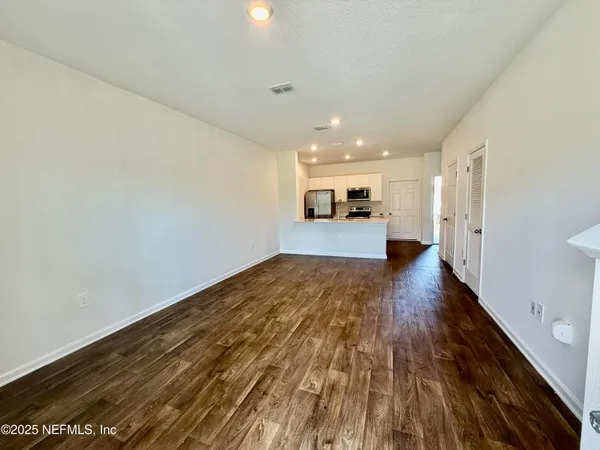 a view of empty room with wooden floor