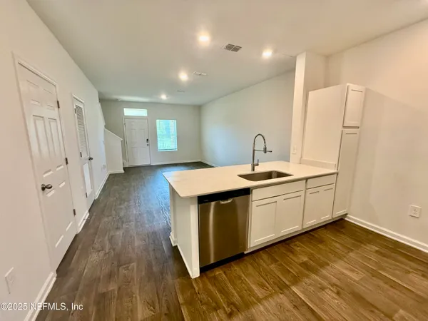 a kitchen with a sink and wooden floor