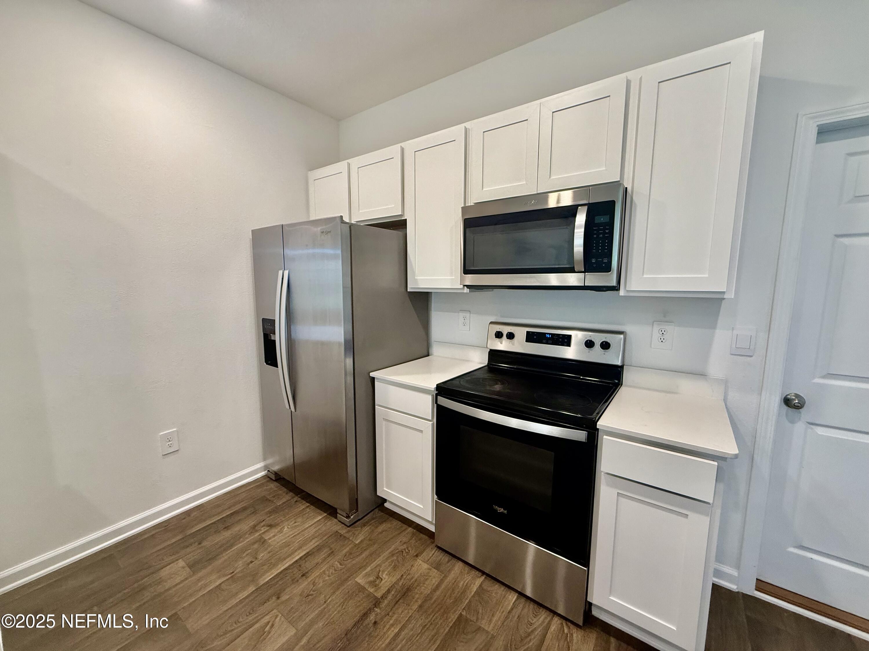 3523 Prairie Wind Court Middleburg, FL 32068 - Photo 4 of 13 a kitchen with white cabinets and stainless steel appliances