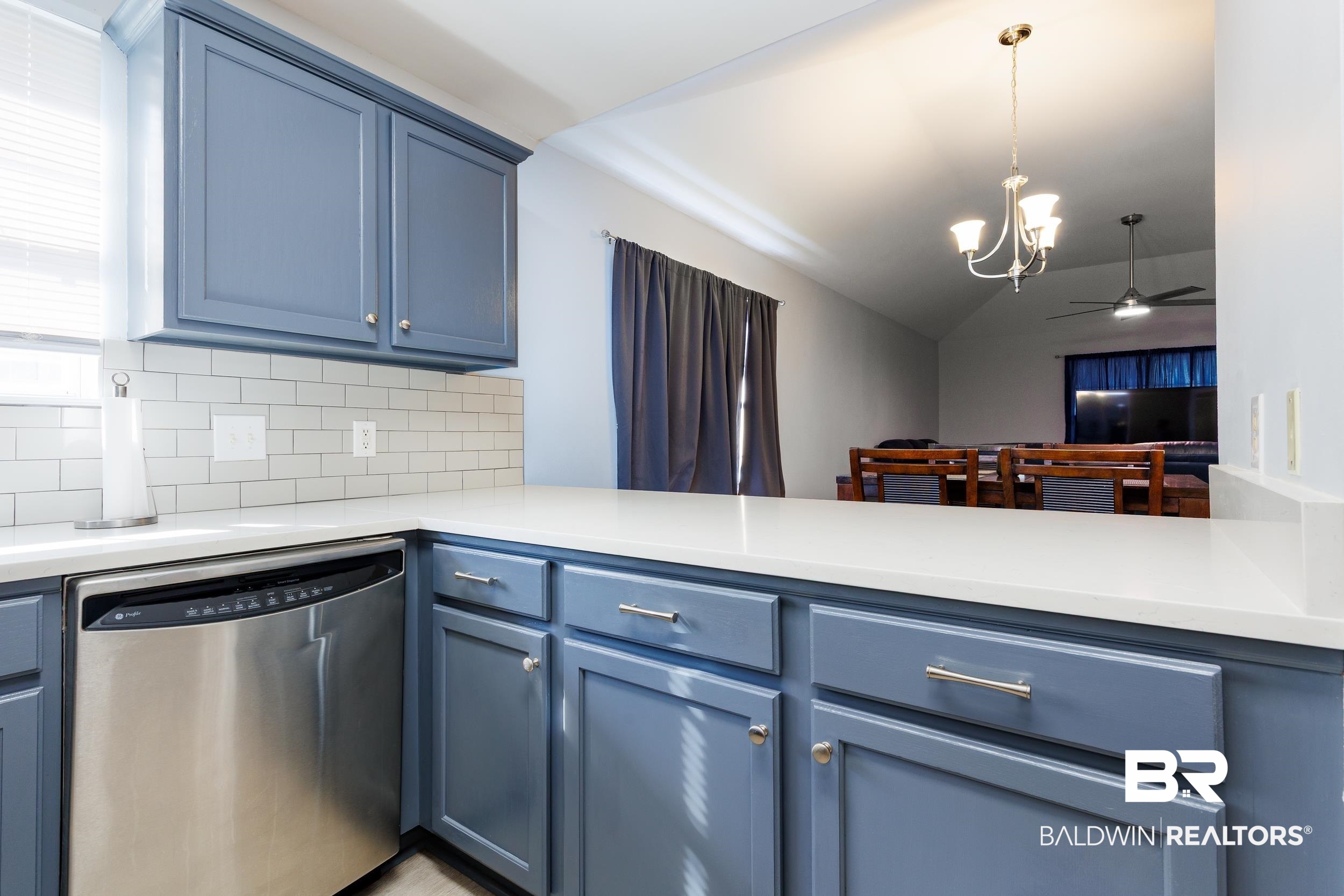 16227 Zenith Drive Loxley, AL 36551 - Photo 5 of 23 Kitchen with blue cabinets, dishwasher, hanging light fixtures, tasteful backsplash, and ceiling fan