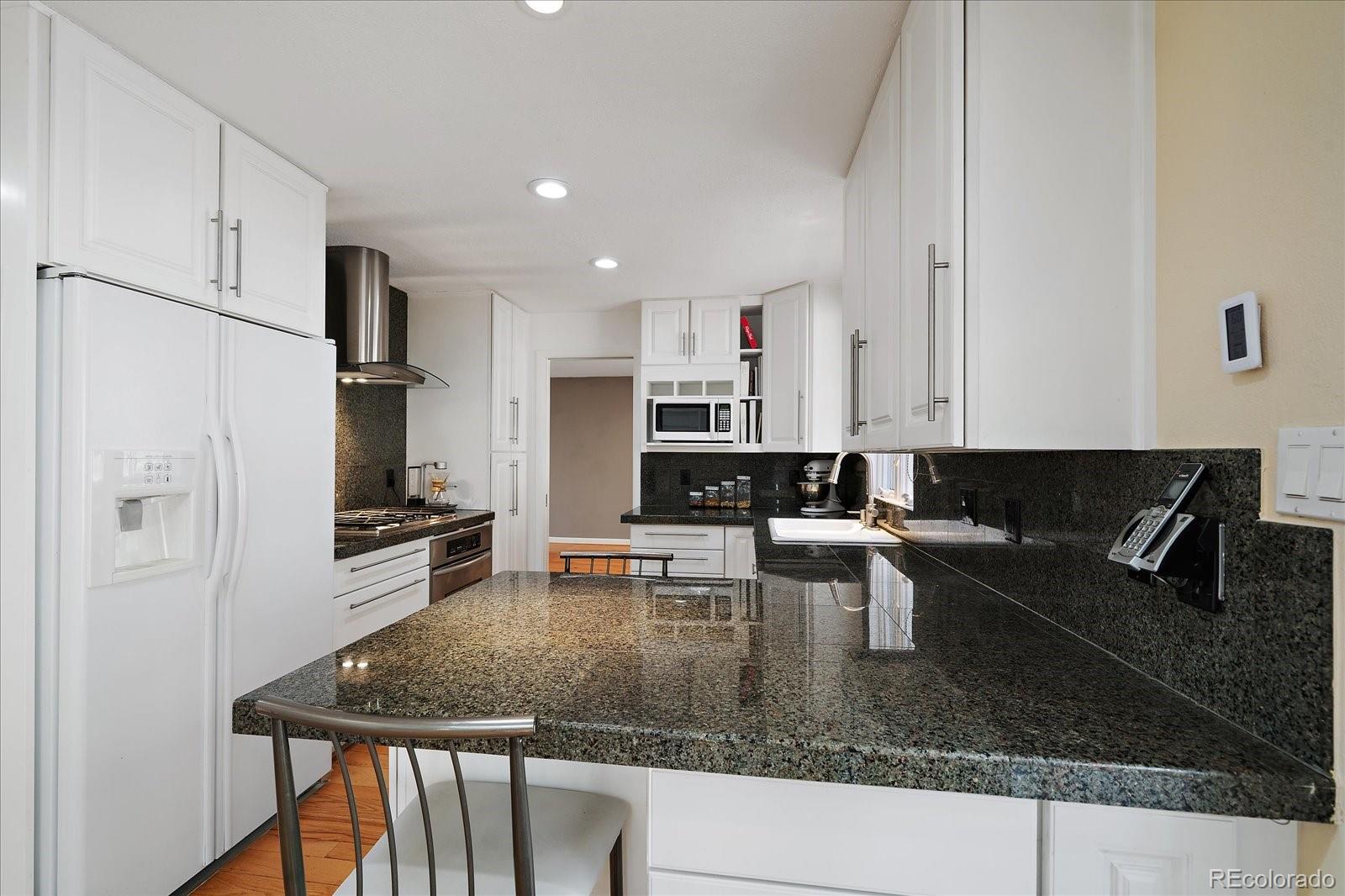 4039 Histead Way Evergreen, CO 80439 - Photo 17 of 48 a kitchen with stainless steel appliances granite countertop a sink a stove and a granite counter top