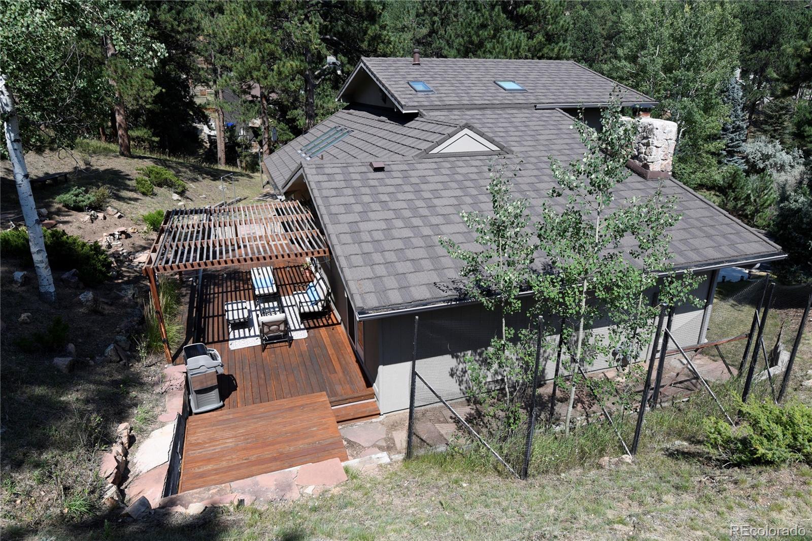 4039 Histead Way Evergreen, CO 80439 - Photo 38 of 48 an aerial view of a house with a yard patio and outdoor seating