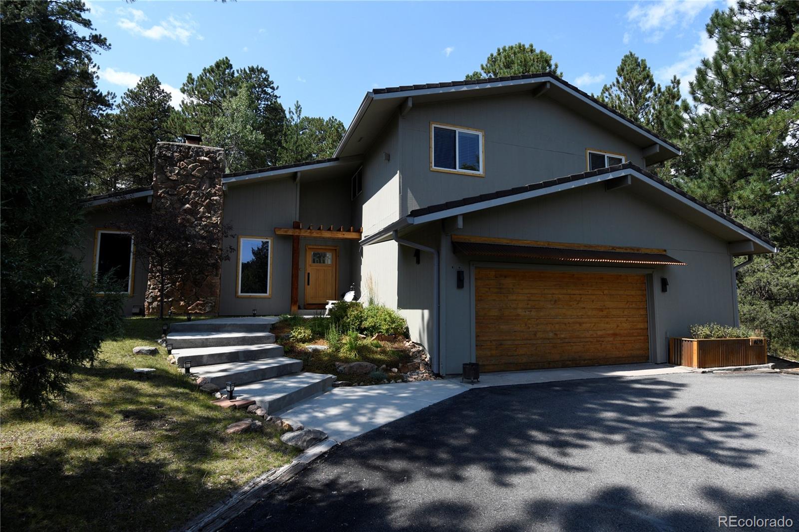 4039 Histead Way Evergreen, CO 80439 - Photo 4 of 48 a front view of a house with a yard and garage