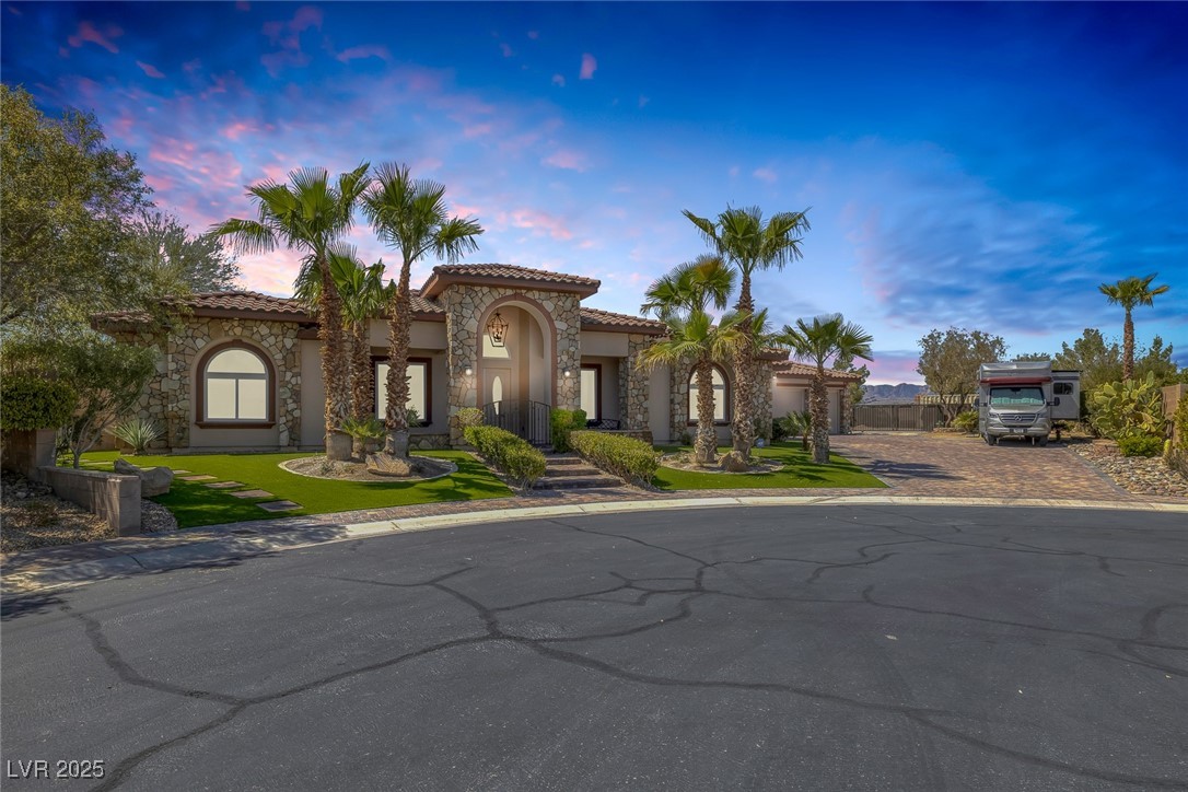 7687 West Pebble Road Las Vegas, NV 89113 - Photo 11 of 79 Mediterranean / spanish-style house featuring a tiled roof, stucco siding, stone siding, and decorative driveway