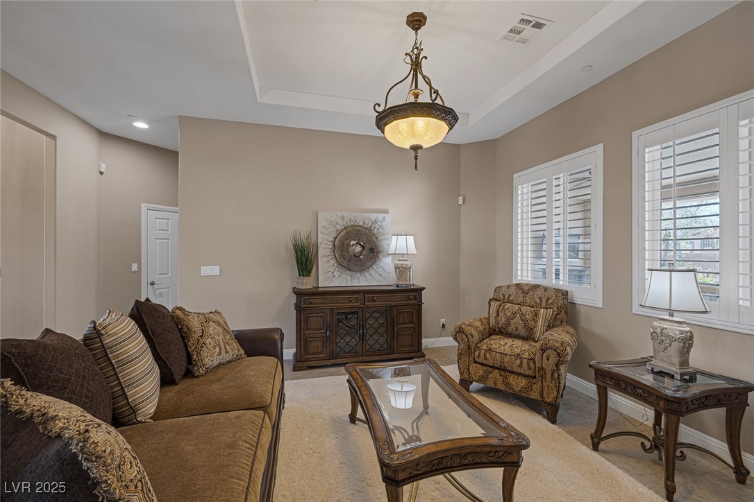 7687 West Pebble Road Las Vegas, NV 89113 - Photo 16 of 79 Carpeted living room with a raised ceiling, baseboards, visible vents, and recessed lighting