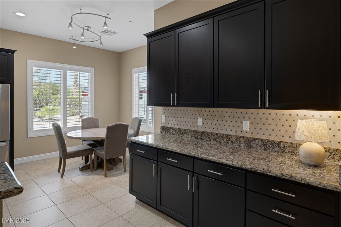 7687 West Pebble Road Las Vegas, NV 89113 - Photo 17 of 79 Kitchen with visible vents, decorative backsplash, and dark cabinets
