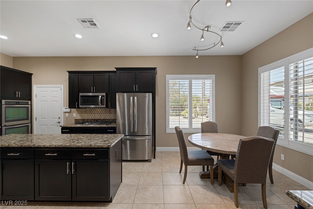 7687 West Pebble Road Las Vegas, NV 89113 - Photo 20 of 79 Kitchen featuring dark cabinetry, plenty of natural light, visible vents, and stainless steel appliances