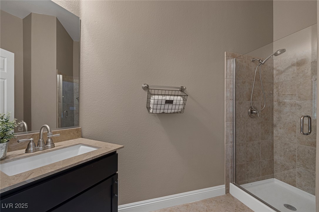 7687 West Pebble Road Las Vegas, NV 89113 - Photo 25 of 79 Full bath featuring a shower stall, vanity, and baseboards