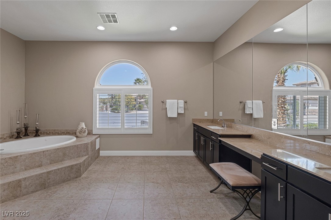 7687 West Pebble Road Las Vegas, NV 89113 - Photo 26 of 79 Full bathroom featuring a garden tub, vanity, tile patterned flooring, visible vents, and baseboards