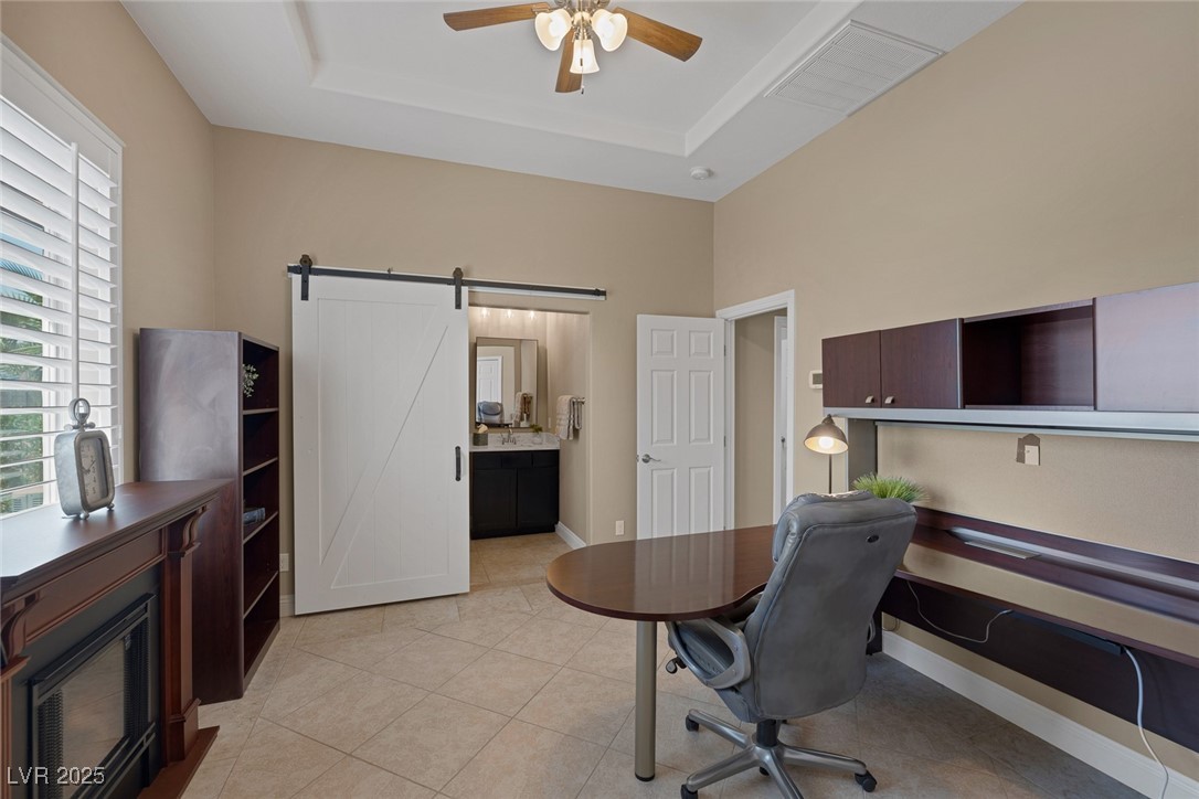 7687 West Pebble Road Las Vegas, NV 89113 - Photo 31 of 79 Home office featuring a tray ceiling, ceiling fan, a barn door, and baseboards